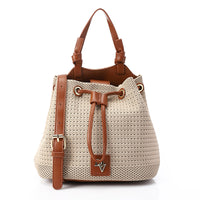 Beige woven handbag with brown leather straps on a white background